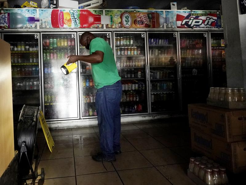 A man uses a flashlight to help others shop in the dark at a convenience store after the effects of Hurricane Ida knocked out power across New Orleans. A man uses a flashlight to help others shop in the dark at a convenience store after the effects of Hurricane Ida knocked out power across New Orleans.