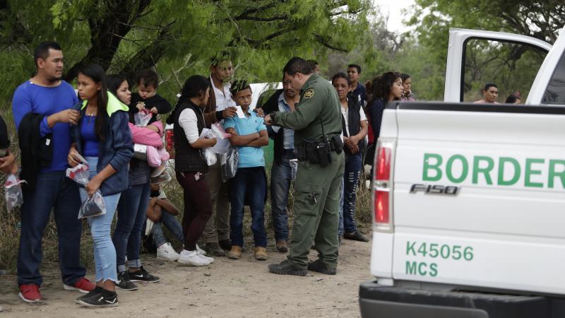 A Border Patrol agent checks the names and documents of families who crossed the nearby U.S.-Mexico border near McAllen, Texas. Immigration authorities say they expect the continuing surge of Central American families crossing the border to multiply in th A Border Patrol agent checks the names and documents of families who crossed the nearby U.S.-Mexico border near McAllen, Texas. Immigration authorities say they expect the continuing surge of Central American families crossing the border to multiply in th