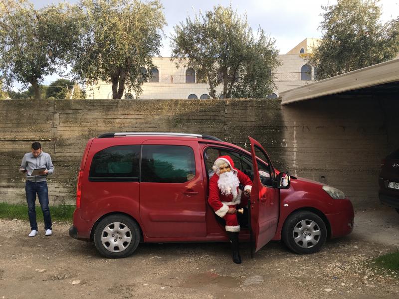 Sabri Canaan, 30, dons a Santa suit to deliver presents as Baba Noel (Father Christmas) on Christmas Eve in Bethlehem. His driver Mohammed Battah (left) briefs him on the list of children receiving gifts. Sabri Canaan, 30, dons a Santa suit to deliver presents as Baba Noel (Father Christmas) on Christmas Eve in Bethlehem. His driver Mohammed Battah (left) briefs him on the list of children receiving gifts.