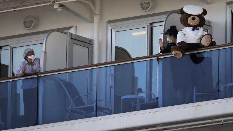 A woman with a teddy bear waves to another passenger as they undergo quarantine on the Diamond Princess cruise ship in Yokohama, Japan. Many passengers are using chat groups and social media to share information with each other. A woman with a teddy bear waves to another passenger as they undergo quarantine on the Diamond Princess cruise ship in Yokohama, Japan. Many passengers are using chat groups and social media to share information with each other.