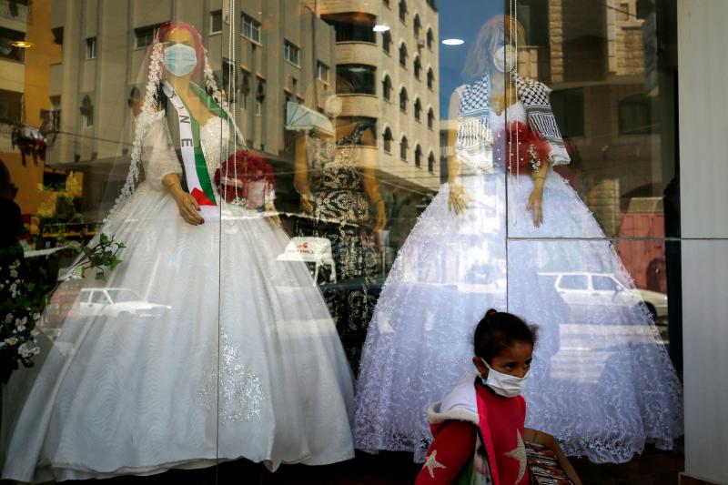 Mannequins dressed in wedding gowns and wearing protective face masks in Gaza City in March. With wedding halls closed and public gatherings forbidden to prevent the spread of the virus, many couples have celebrated their marriage in alleyways and apartme Mannequins dressed in wedding gowns and wearing protective face masks in Gaza City in March. With wedding halls closed and public gatherings forbidden to prevent the spread of the virus, many couples have celebrated their marriage in alleyways and apartme