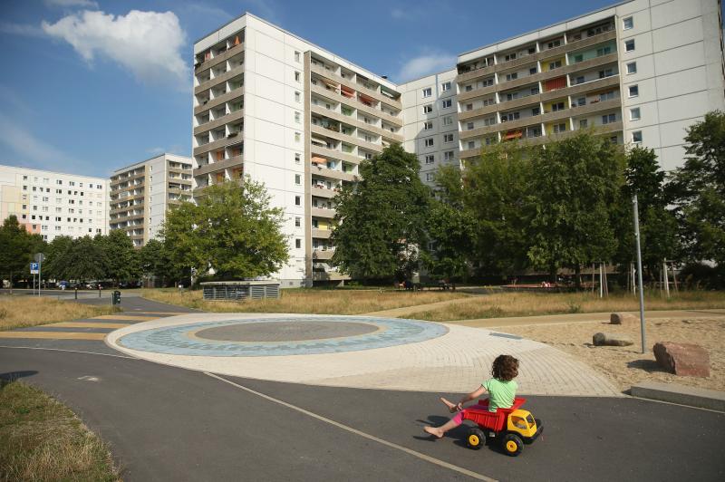 A child plays near communist-era apartment blocks in Hoyerswerda, Germany. After the collapse of the communist East German government that had redeveloped the area into an industrial hub, factories shut down and coal production declined. The population ha A child plays near communist-era apartment blocks in Hoyerswerda, Germany. After the collapse of the communist East German government that had redeveloped the area into an industrial hub, factories shut down and coal production declined. The population ha