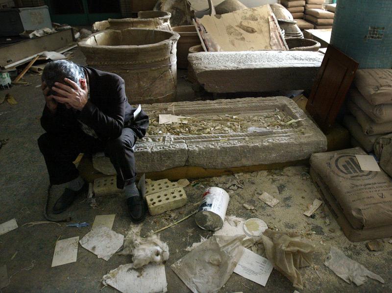 Iraqi National Museum Deputy Director Musin Hassan holds his head in his hands as he sits amid destroyed artifacts in the Baghdad museum in 2003. Iraqi National Museum Deputy Director Musin Hassan holds his head in his hands as he sits amid destroyed artifacts in the Baghdad museum in 2003.