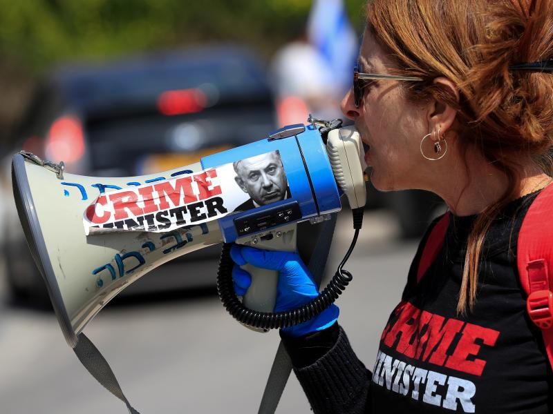 An anti-Netanyahu protester shouts slogans during a demonstration in front of the Knesset in Jerusalem on Wednesday. An anti-Netanyahu protester shouts slogans during a demonstration in front of the Knesset in Jerusalem on Wednesday.