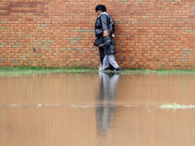 A woman and a young boy walk along a wall of the Guardian Court Apartments as high water forced some to leave their homes after heavy rains of up to seven inches caused flash flooding in Louisville, Kentucky on Friday. A woman and a young boy walk along a wall of the Guardian Court Apartments as high water forced some to leave their homes after heavy rains of up to seven inches caused flash flooding in Louisville, Kentucky on Friday.