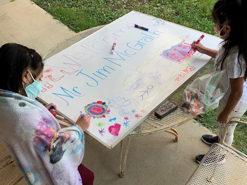 Nicole, a kindergartner, and Angelique, a third grader, make a poster welcoming a regular visitor to the learning hub who teaches the children how to care for their pets: Persephone the guinea pig and George Kiwi the turtle. Nicole, a kindergartner, and Angelique, a third grader, make a poster welcoming a regular visitor to the learning hub who teaches the children how to care for their pets: Persephone the guinea pig and George Kiwi the turtle.