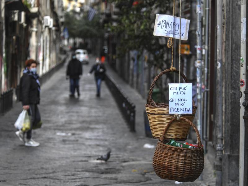 A solidarity basket with a note reading "Those who can, put something in, those who can't, help yourself" is hung in the historic center of Naples. A solidarity basket with a note reading "Those who can, put something in, those who can't, help yourself" is hung in the historic center of Naples.