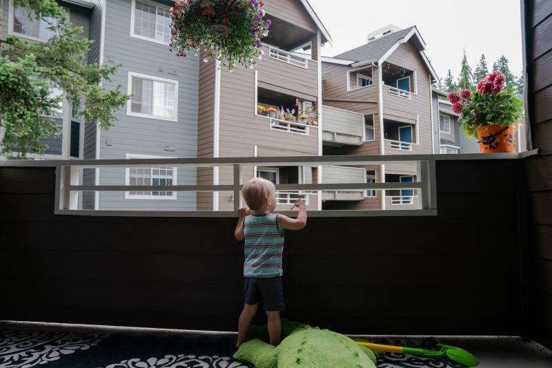 Grigory Vodolazov's 3-year-old son peers into his family's apartment complex from their unit in Bellevue, Wash. The Vodolazov family is part of Creating Moves to Opportunity, a housing voucher experiment that uses incentives and counseling to encourage lo Grigory Vodolazov's 3-year-old son peers into his family's apartment complex from their unit in Bellevue, Wash. The Vodolazov family is part of Creating Moves to Opportunity, a housing voucher experiment that uses incentives and counseling to encourage lo