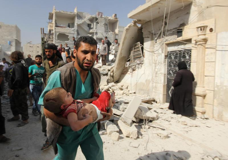 A first responder in the rebel-held city of Aleppo carries a child who was wounded in a government airstrike on Sept. 16. A first responder in the rebel-held city of Aleppo carries a child who was wounded in a government airstrike on Sept. 16.