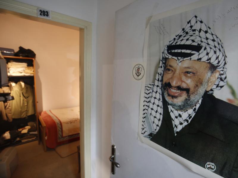A photograph of the late Palestinian leader Yasser Arafat hangs outside a door leading to the small bedroom where he spent his final years, a display at the new Arafat Museum in the West Bank city of Ramallah. A photograph of the late Palestinian leader Yasser Arafat hangs outside a door leading to the small bedroom where he spent his final years, a display at the new Arafat Museum in the West Bank city of Ramallah.