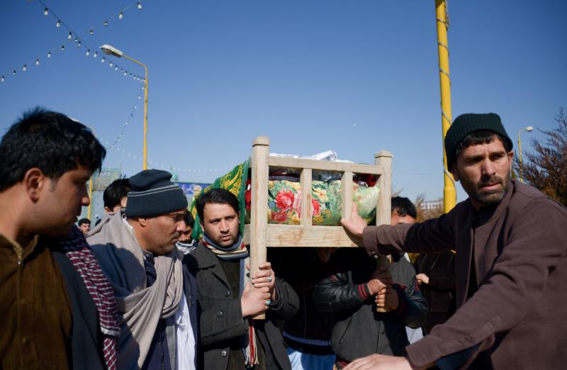 Mourners carry the coffin of one of six Afghan employees of the Red Cross killed in an attack in a remote northern province in February. Mourners carry the coffin of one of six Afghan employees of the Red Cross killed in an attack in a remote northern province in February.