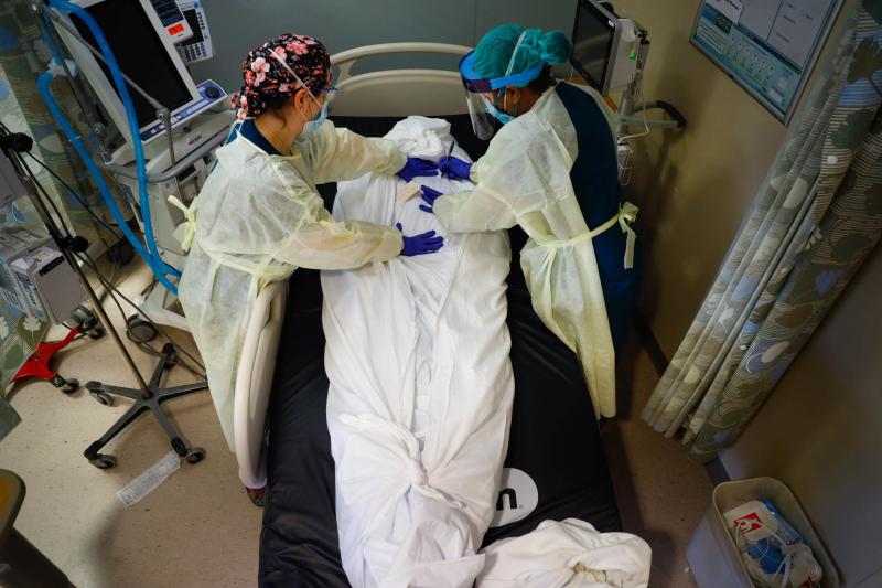 Nurse educator Katie Demelis and nurse manager Nydia White wrap the the body of a patient who died of COVID-19 at Mount Sinai South Nassau hospital in Oceanside, N.Y., on April 15, 2020. Nurse educator Katie Demelis and nurse manager Nydia White wrap the the body of a patient who died of COVID-19 at Mount Sinai South Nassau hospital in Oceanside, N.Y., on April 15, 2020.