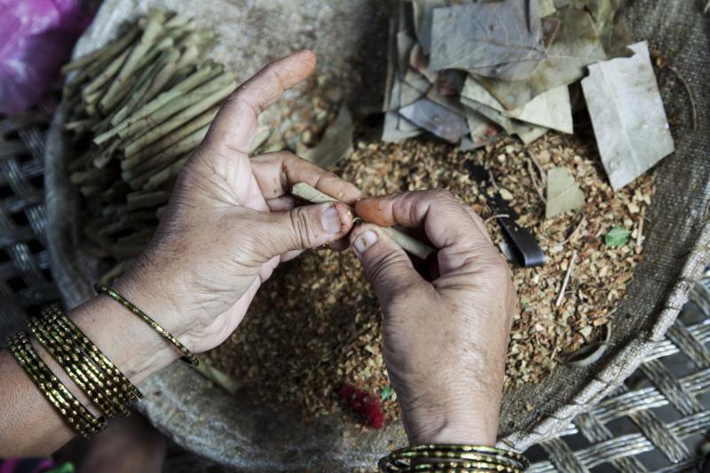 A woman rolls tobacco inside a tendu leaf to make a beedi cigarette at her home in Kannauj, Uttar Pradesh, India, on Wednesday, June 3, 2015. India's smokers favor cheaper options such as chewing and leaf-wrapped tobacco over cigarettes. A woman rolls tobacco inside a tendu leaf to make a beedi cigarette at her home in Kannauj, Uttar Pradesh, India, on Wednesday, June 3, 2015. India's smokers favor cheaper options such as chewing and leaf-wrapped tobacco over cigarettes.