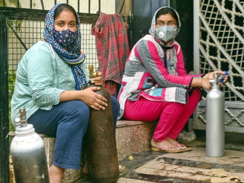 India has reported more than 20 million coronavirus cases, adding more than 2.6 million new cases in the past week alone. Here, women wait to refill empty oxygen cylinders in New Delhi. Oxygen shortages are blamed for deaths at even the best-equipped urba India has reported more than 20 million coronavirus cases, adding more than 2.6 million new cases in the past week alone. Here, women wait to refill empty oxygen cylinders in New Delhi. Oxygen shortages are blamed for deaths at even the best-equipped urba