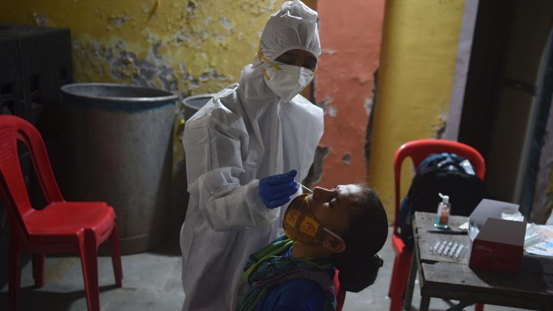 A health worker wearing protective gear collects a swab sample during a medical screening for the coronavirus in Mumbai on Wednesday. The number of registered coronavirus cases passed 5 million on Wednesday. A health worker wearing protective gear collects a swab sample during a medical screening for the coronavirus in Mumbai on Wednesday. The number of registered coronavirus cases passed 5 million on Wednesday.