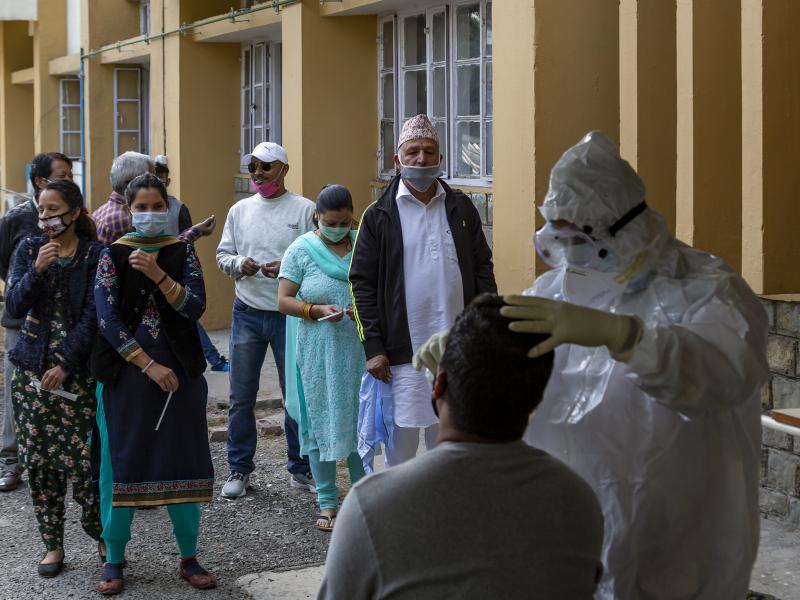 A health officer in a protective suit collects a swab sample to be tested for the coronavirus on Thursday in Dharmsala, India. India's confirmed coronavirus caseload surpassed 8 million on Thursday. A health officer in a protective suit collects a swab sample to be tested for the coronavirus on Thursday in Dharmsala, India. India's confirmed coronavirus caseload surpassed 8 million on Thursday.