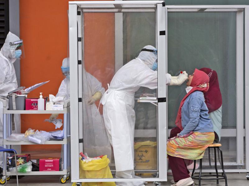 A medical worker collects nasal swab samples this week during a mass test for the coronavirus at North Sumatra University in Medan, Indonesia. The mass test was held after the rector of the university, one of his deputies and a member of the board of trus A medical worker collects nasal swab samples this week during a mass test for the coronavirus at North Sumatra University in Medan, Indonesia. The mass test was held after the rector of the university, one of his deputies and a member of the board of trus