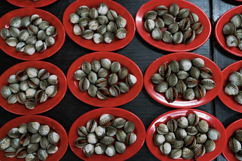 Plates of blood clams are on display at a stand in one of Jakarta's outdoor food courts. Plates of blood clams are on display at a stand in one of Jakarta's outdoor food courts.