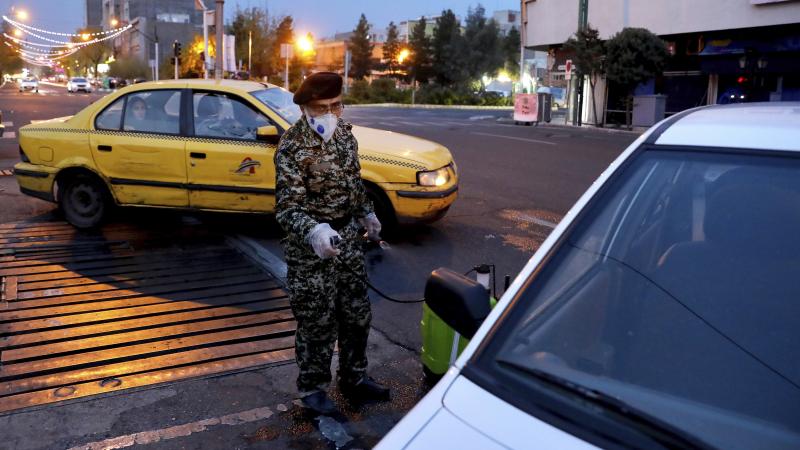 In Tehran a member of the Revolutionary Guard disinfects a car on Wednesday, to help prevent the spread of the coronavirus. In Tehran a member of the Revolutionary Guard disinfects a car on Wednesday, to help prevent the spread of the coronavirus.
