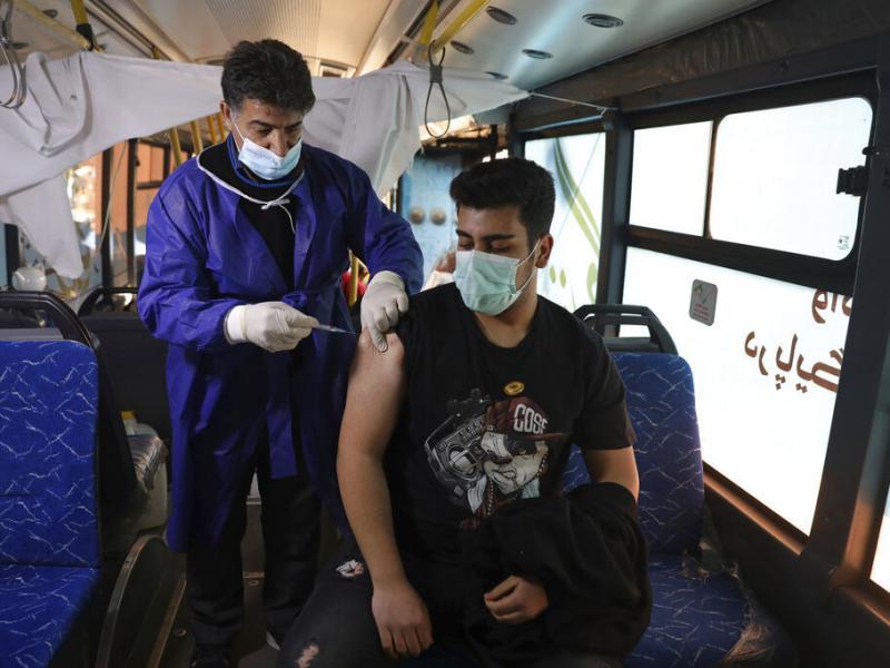 A man receives a COVID-19 vaccine at a mobile vaccine clinic bus at the Grand Bazaar of Tehran, Iran, Saturday, Jan. 22, 2022. A man receives a COVID-19 vaccine at a mobile vaccine clinic bus at the Grand Bazaar of Tehran, Iran, Saturday, Jan. 22, 2022.