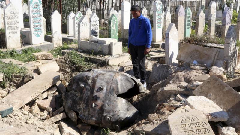 A man looks at an unexploded barrel bomb that landed in a cemetery after being dropped by forces loyal to Syria's President Bashar Assad in the northern Syrian city of Aleppo on Thursday. A man looks at an unexploded barrel bomb that landed in a cemetery after being dropped by forces loyal to Syria's President Bashar Assad in the northern Syrian city of Aleppo on Thursday.