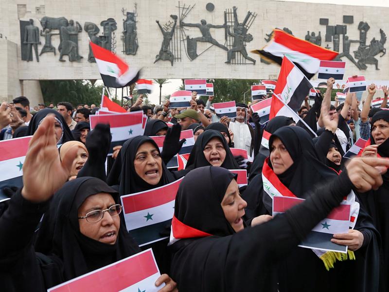 Protesters shout slogans as they wave Iraqi and Syrian flags in Tahrir Square in Baghdad on Sunday. Protesters shout slogans as they wave Iraqi and Syrian flags in Tahrir Square in Baghdad on Sunday.
