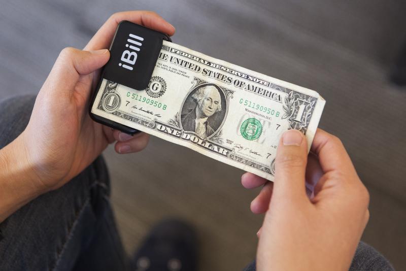 After scanning a $1 bill with iBill, a speaker announces, "one dollar." After scanning a $1 bill with iBill, a speaker announces, "one dollar."