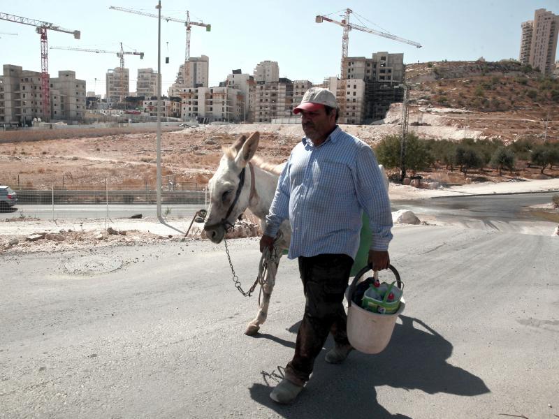 A Palestinian man walks near a construction site of a new housing unit in a neighborhood in East Jerusalem known to Jewish settlers as Har Homa and to Palestinians as Jabal Abu Ghneim. The Palestinians want East Jerusalem to be the capital of a future sta A Palestinian man walks near a construction site of a new housing unit in a neighborhood in East Jerusalem known to Jewish settlers as Har Homa and to Palestinians as Jabal Abu Ghneim. The Palestinians want East Jerusalem to be the capital of a future sta