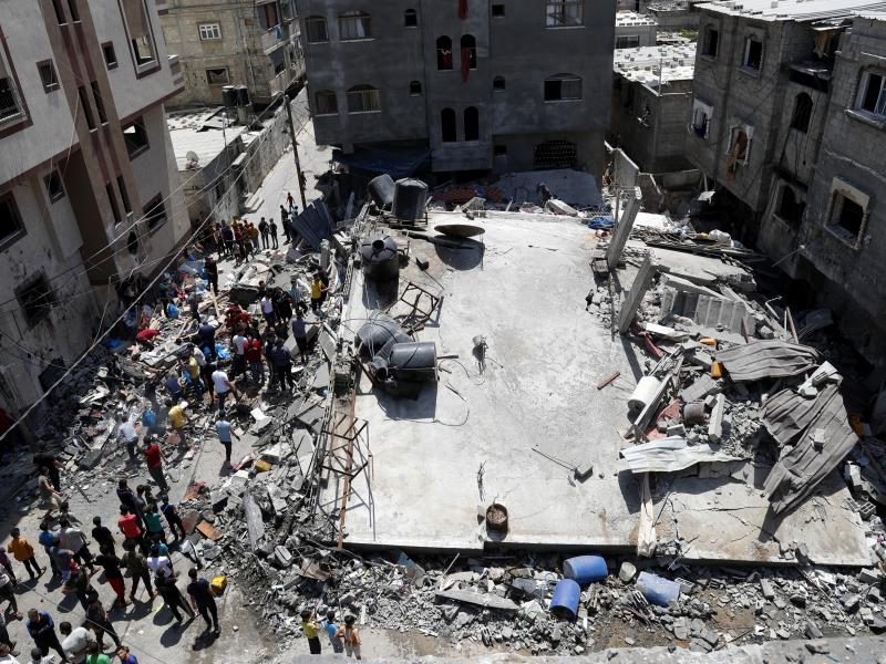 People gather near the rubble of a residential building hit by Israeli airstrikes Thursday in Beit Lahiya, Gaza Strip. People gather near the rubble of a residential building hit by Israeli airstrikes Thursday in Beit Lahiya, Gaza Strip.