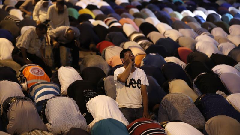 Palestinian Muslim worshippers pray outside an entrance to the Al-Aqsa mosque compound in Jerusalem's Old City on Sunday. They gathered to protest new Israeli security measures implemented at the holy site following an attack that killed two Israeli polic Palestinian Muslim worshippers pray outside an entrance to the Al-Aqsa mosque compound in Jerusalem's Old City on Sunday. They gathered to protest new Israeli security measures implemented at the holy site following an attack that killed two Israeli polic