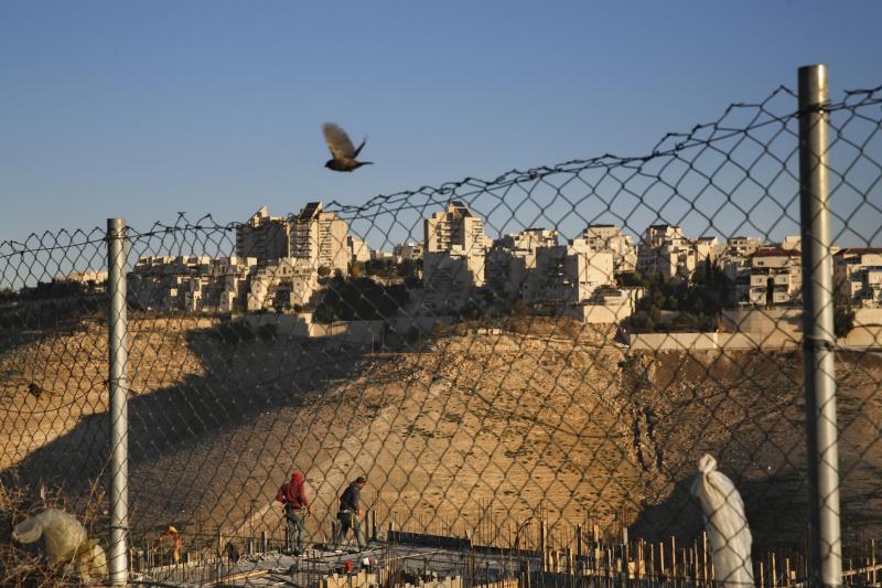 Palestinian laborers work at a construction site in a new housing project in the Israeli settlement of Maale Adumim on Tuesday, after Israel's parliament approved a law that retroactively legalizes thousands of West Bank settlement homes built unlawfully Palestinian laborers work at a construction site in a new housing project in the Israeli settlement of Maale Adumim on Tuesday, after Israel's parliament approved a law that retroactively legalizes thousands of West Bank settlement homes built unlawfully