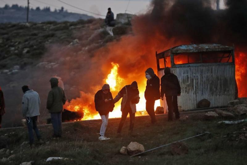 Jewish settlers set tires ablaze at the Amona outpost, northeast of Ramallah, on Wednesday. Jewish settlers set tires ablaze at the Amona outpost, northeast of Ramallah, on Wednesday.