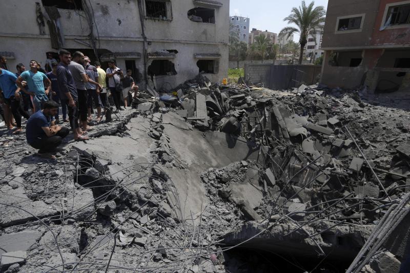 Gaza residents on Saturday inspect the rubble of a destroyed residential building hit by Israeli airstrikes. Gaza residents on Saturday inspect the rubble of a destroyed residential building hit by Israeli airstrikes.