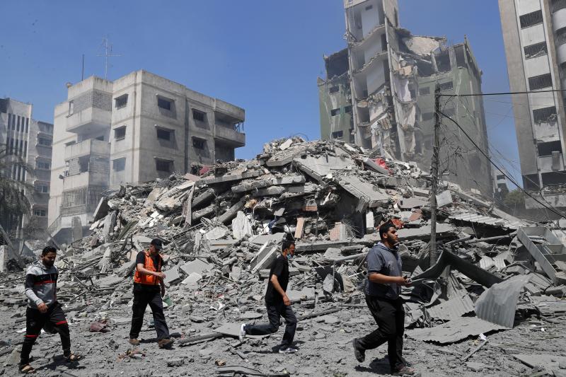 People inspect the rubble of a residential building that was destroyed by an Israeli airstrike in Gaza City on Sunday. People inspect the rubble of a residential building that was destroyed by an Israeli airstrike in Gaza City on Sunday.