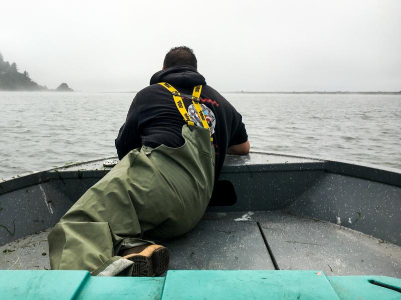 Jerome Nick Jr. perches in the front of the boat, checking to see if any Yurok tribal members are fishing. Jerome Nick Jr. perches in the front of the boat, checking to see if any Yurok tribal members are fishing.