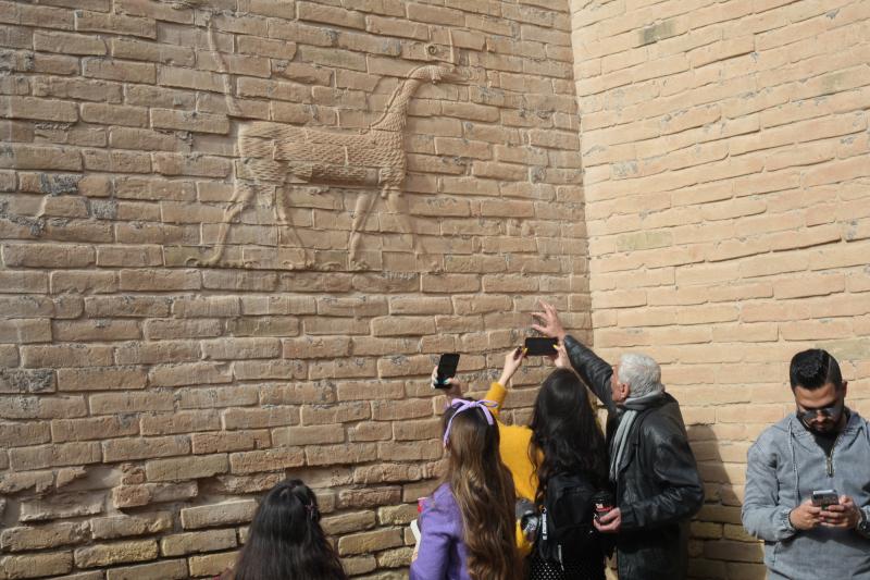 Visitors with the Bil Weekend tourism company take photographs inside the ruins of the ancient city of Babylon, in the area around the Ishtar gate. The animal on the walls ins a dragon-like creature associated with the Babylonian god Marduk. Visitors with the Bil Weekend tourism company take photographs inside the ruins of the ancient city of Babylon, in the area around the Ishtar gate. The animal on the walls ins a dragon-like creature associated with the Babylonian god Marduk.