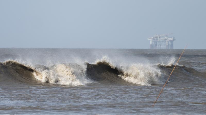 Hurricane Laura sends large waves crashing on a beach in Cameron, La., on Aug. 26 as an offshore oil rig appears in the distance. The most active hurricane season on record was just one of many challenges facing the oil industry this year — aside from t Hurricane Laura sends large waves crashing on a beach in Cameron, La., on Aug. 26 as an offshore oil rig appears in the distance. The most active hurricane season on record was just one of many challenges facing the oil industry this year — aside from t