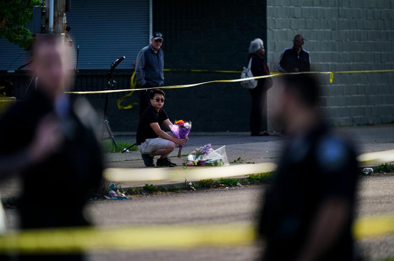 A person places flowers outside the scene of the mass shooting at a supermarket in Buffalo, N.Y., on Sunday. A person places flowers outside the scene of the mass shooting at a supermarket in Buffalo, N.Y., on Sunday.