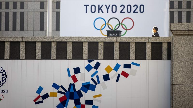 A pedestrian walks past an official Tokyo 2020 Olympic Games banner hanging on the Tokyo Metropolitan Government Building on Friday. A pedestrian walks past an official Tokyo 2020 Olympic Games banner hanging on the Tokyo Metropolitan Government Building on Friday.