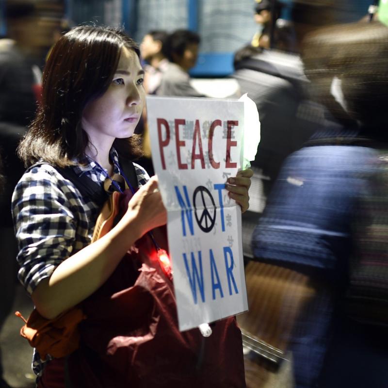A young woman holds a placard protesting against controversial military reform bills outside Japan's parliament in Tokyo, Japan, on Friday. Lawmakers passed two measures to expand the role of Japan's military for the first time since World War II. A young woman holds a placard protesting against controversial military reform bills outside Japan's parliament in Tokyo, Japan, on Friday. Lawmakers passed two measures to expand the role of Japan's military for the first time since World War II.