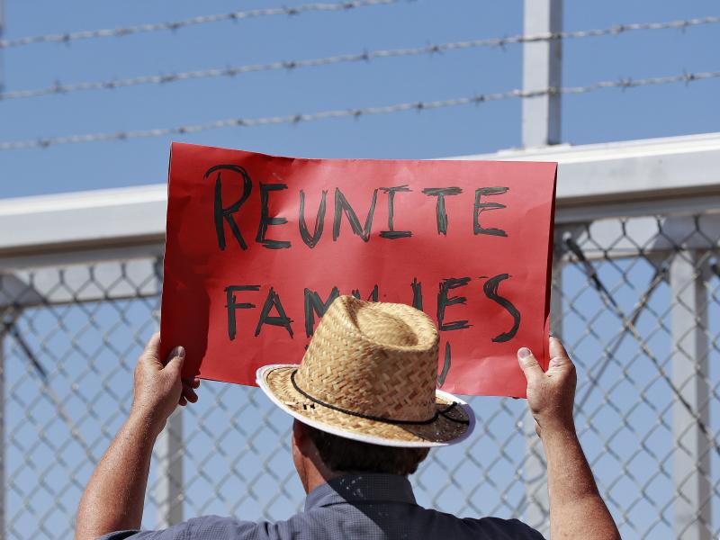 A protester holds a sign outside a closed gate at the Port of Entry facility, last week in Fabens, Texas, where tent shelters are being used to house separated family members. A protester holds a sign outside a closed gate at the Port of Entry facility, last week in Fabens, Texas, where tent shelters are being used to house separated family members.