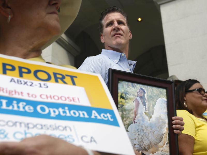 Dan Diaz holds a photo of his late wife, Brittany Maynard, taken on their wedding day, during a rally calling for California Gov. Jerry Brown to sign right-to-die legislation at the Capitol in Sacramento in 2015. Dan Diaz holds a photo of his late wife, Brittany Maynard, taken on their wedding day, during a rally calling for California Gov. Jerry Brown to sign right-to-die legislation at the Capitol in Sacramento in 2015.