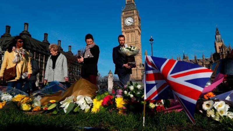 People lay floral tributes to the victims of the March 22 terror attack in Parliament Square outside the Houses of Parliament in central London. People lay floral tributes to the victims of the March 22 terror attack in Parliament Square outside the Houses of Parliament in central London.