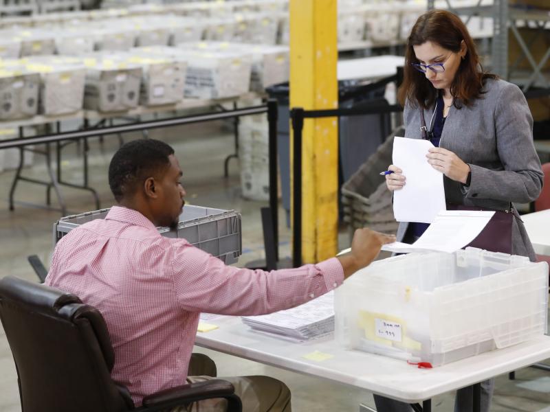 A Republican party observer, right, watches as an employee at the Palm Beach County Supervisor Of Elections office goes through a stack of damaged ballots, Thursday, Nov. 15, 2018, in West Palm Beach, Fla. A Republican party observer, right, watches as an employee at the Palm Beach County Supervisor Of Elections office goes through a stack of damaged ballots, Thursday, Nov. 15, 2018, in West Palm Beach, Fla.