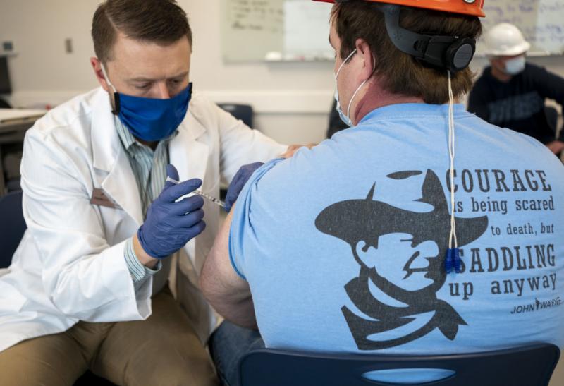 A pharmacist administers a dose of a COVID-19 vaccine to a worker at a processing plant in Arkansas City, Kan., on March 5. Researchers are concerned that vaccination rates in some rural communities may not keep up with urban rates. A pharmacist administers a dose of a COVID-19 vaccine to a worker at a processing plant in Arkansas City, Kan., on March 5. Researchers are concerned that vaccination rates in some rural communities may not keep up with urban rates.