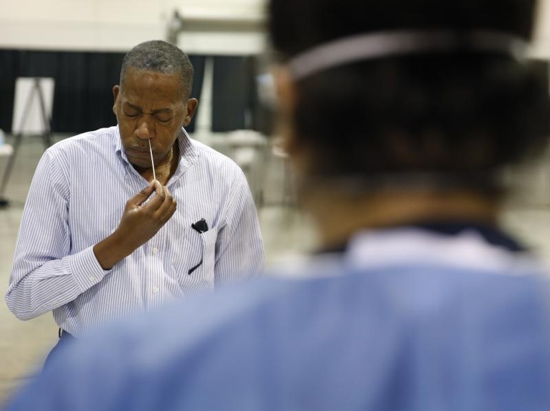 Clark County Commission Vice Chairman Lawrence Weekly swabs his nose while giving a coronavirus test to himself during a tour of setup at a temporary coronavirus testing site in Las Vegas on Aug. 3. Clark County Commission Vice Chairman Lawrence Weekly swabs his nose while giving a coronavirus test to himself during a tour of setup at a temporary coronavirus testing site in Las Vegas on Aug. 3.