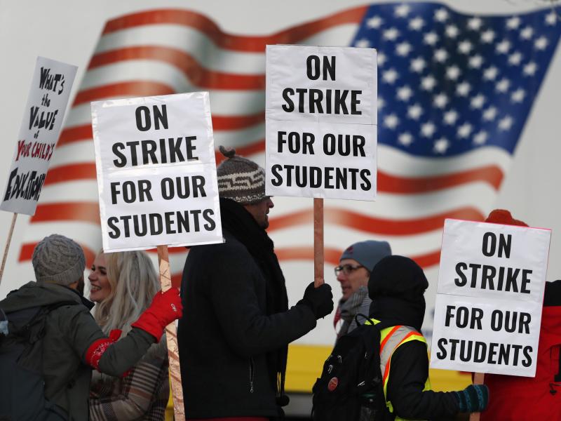 Teachers carry placards as they walk a picket line outside South High School early Monday in Denver. A new lawsuit alleges students with disabilities will be harmed by the strike. Teachers carry placards as they walk a picket line outside South High School early Monday in Denver. A new lawsuit alleges students with disabilities will be harmed by the strike.