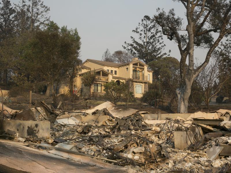 A large home that survived last week's wildfire sits by the burned ruins of one that did not, on Monday in Santa Rosa, Calif. A large home that survived last week's wildfire sits by the burned ruins of one that did not, on Monday in Santa Rosa, Calif.