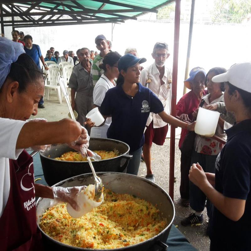Men, women and children line up for free lunch at a soup kitchen in Maracaibo, Venezuela. The meal consists of a bottle of milk and a few scoops of rice mixed with eggs and vegetables. Men, women and children line up for free lunch at a soup kitchen in Maracaibo, Venezuela. The meal consists of a bottle of milk and a few scoops of rice mixed with eggs and vegetables.