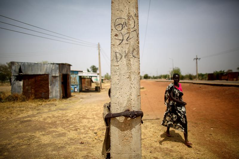 The town of Bentiu, in South Sudan, has been nearly abandoned. On the main road, a boy hides behind a telephone pole. The town of Bentiu, in South Sudan, has been nearly abandoned. On the main road, a boy hides behind a telephone pole.